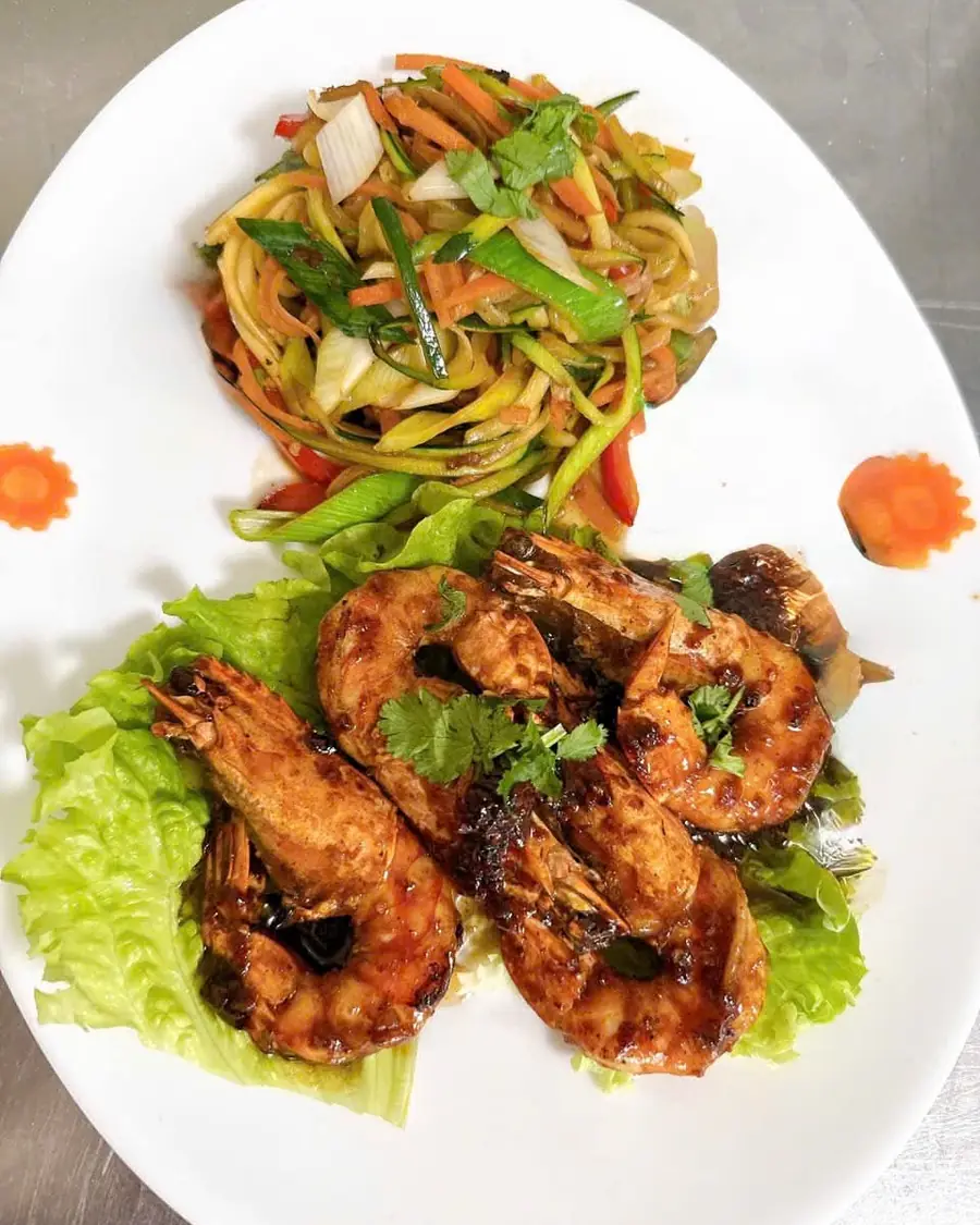 Gambas laquées servies avec des nouilles sautées aux légumes croquants